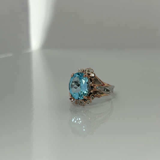Ring with a blue gemstone on a reflective surface