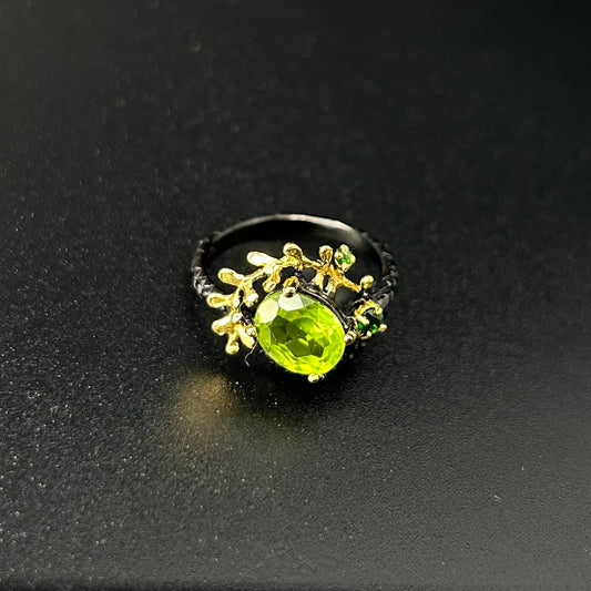 Ring with green gemstone and gold detailing on a black background