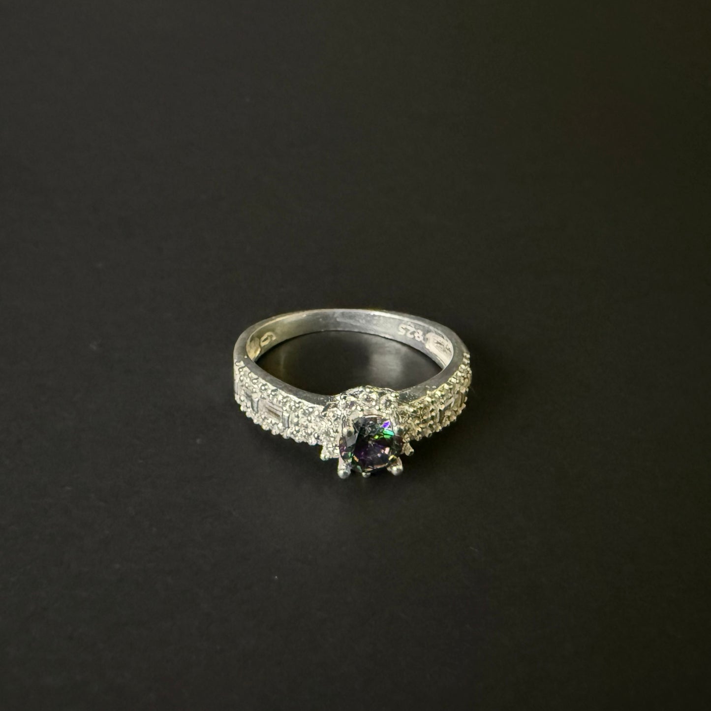 Silver ring with a colorful mystic quartz on a light purple background