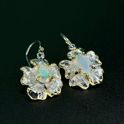 Floral earrings with Ethiopian opal stones on a black background