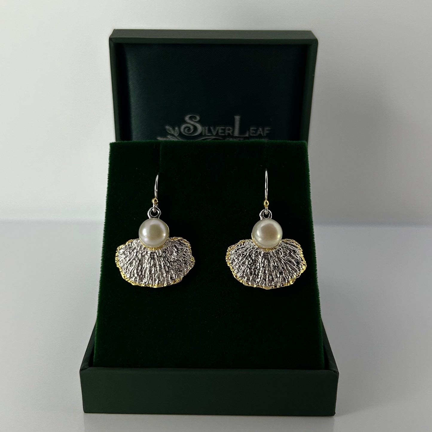 Pair of earrings with pearl and leaf design in a 'Silver Leaf' branded box.