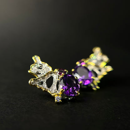 Gold and purple amethyst gemstone earrings on a black background