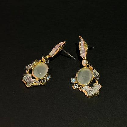 Pair of silver and gemstone earrings on a black background