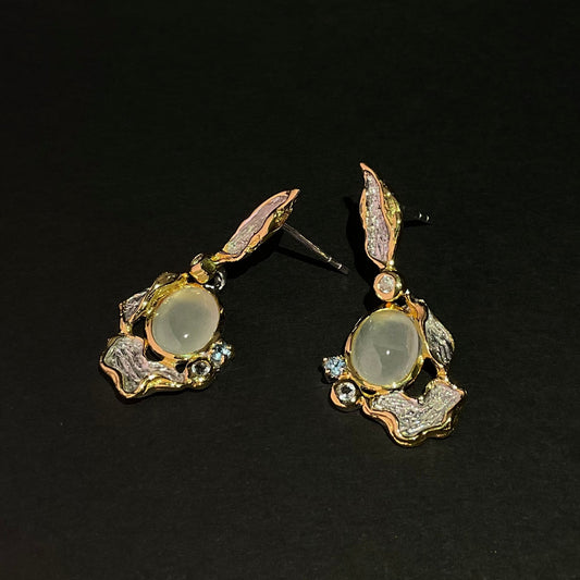 Pair of silver and gemstone earrings on a black background