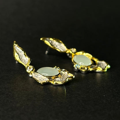 Pair of silver earrings with gemstones on a black background