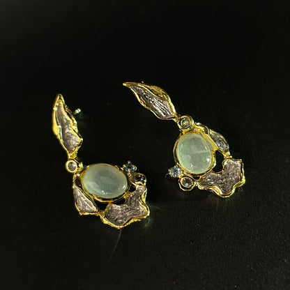 Pair of silver earrings with gemstones on a black background