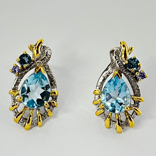 Pair of silver earrings with Sky London Topaz on a light gray background