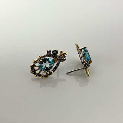 Pair of earrings with blue topaz on a light gray background