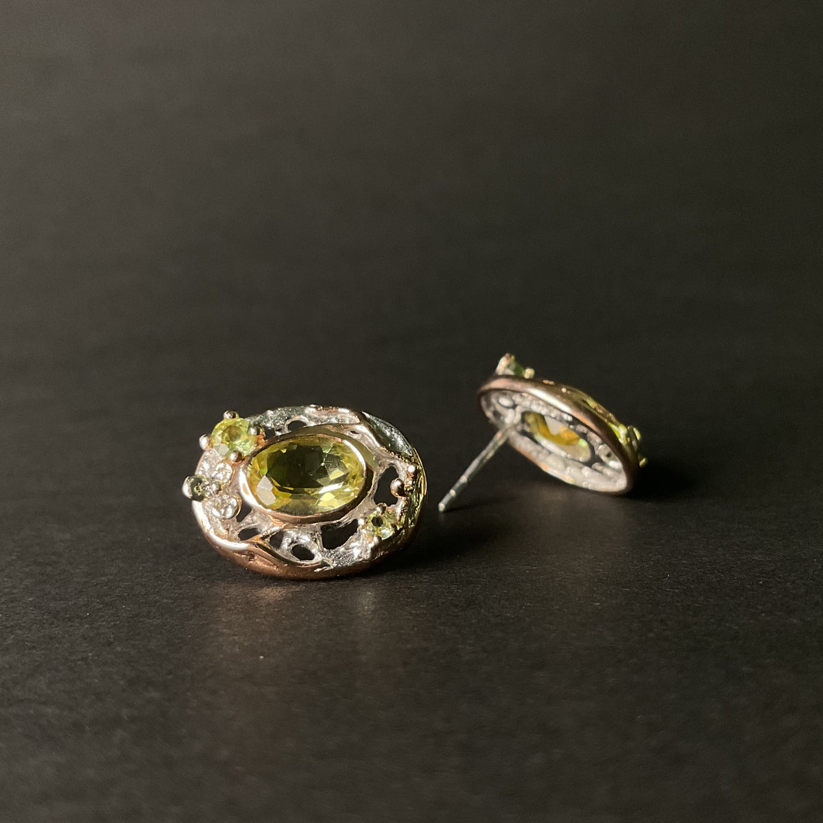 Pair of earrings with green gemstones on a dark background