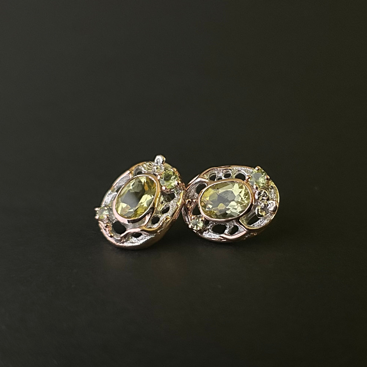 Pair of sterling silver earrings with green gemstones on a black background