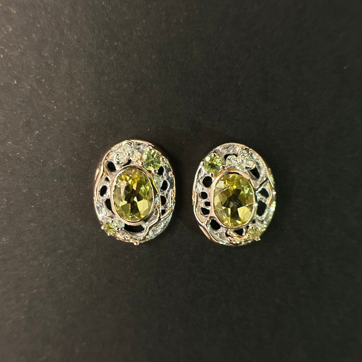 Pair of sterling silver earrings with green gemstones on a black background