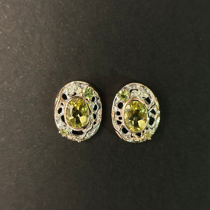Pair of sterling silver earrings with green gemstones on a black background