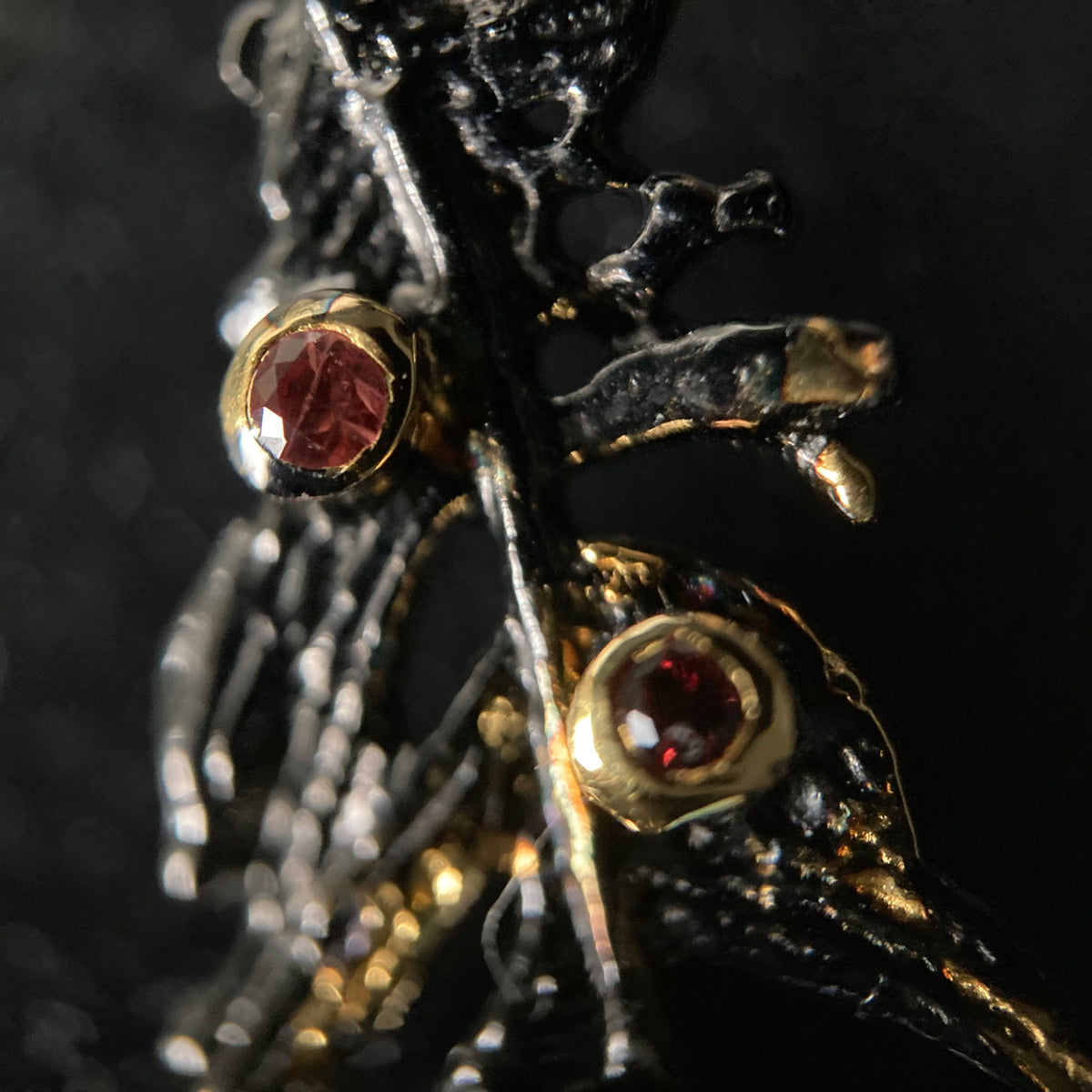 Close-up of a decorative earring with gemstones on a dark background
