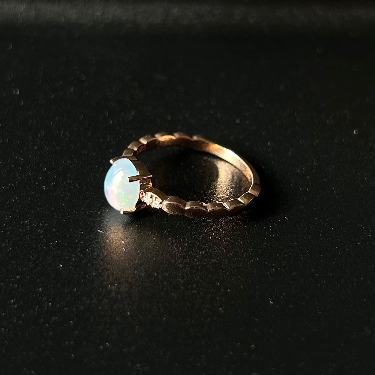 Silver ring with an opal stone on a black background