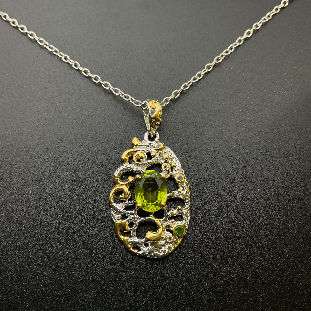 Decorative necklace with a green peridot gemstone on a dark background
