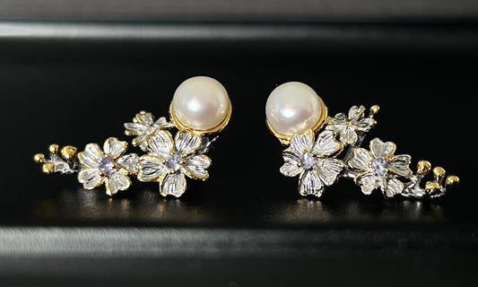 Pair of floral earrings with pearls on a black background