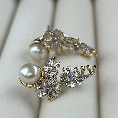 Gold and silver floral earrings with pearls on a white background