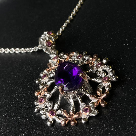 Jewelry silver pendant with purple amethyst gemstone on a black background