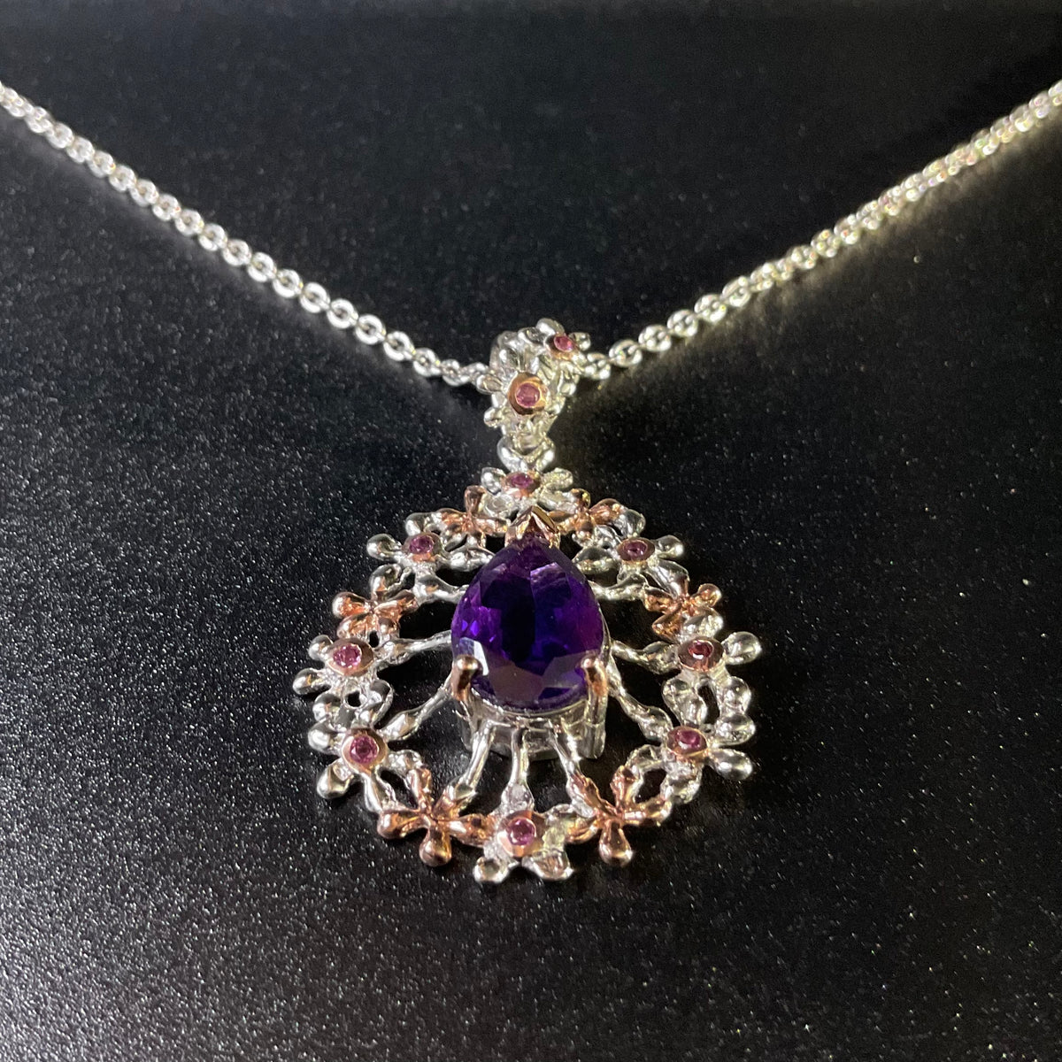 Jewelry pendant with purple gemstone on a black background