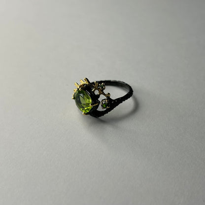 Ring with a green gemstone on a gray background