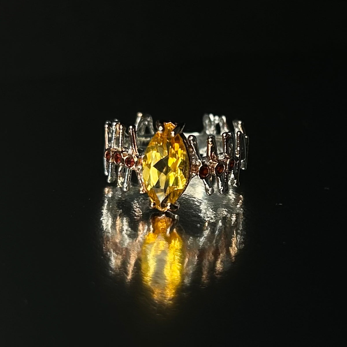 Silver ring with a yellow Citrine gemstone on a dark background