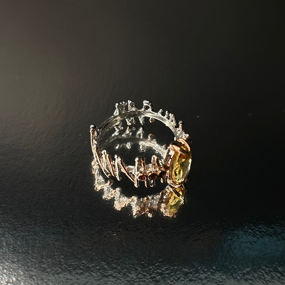 Silver ring with a yellow Citrine gemstone on a dark background
