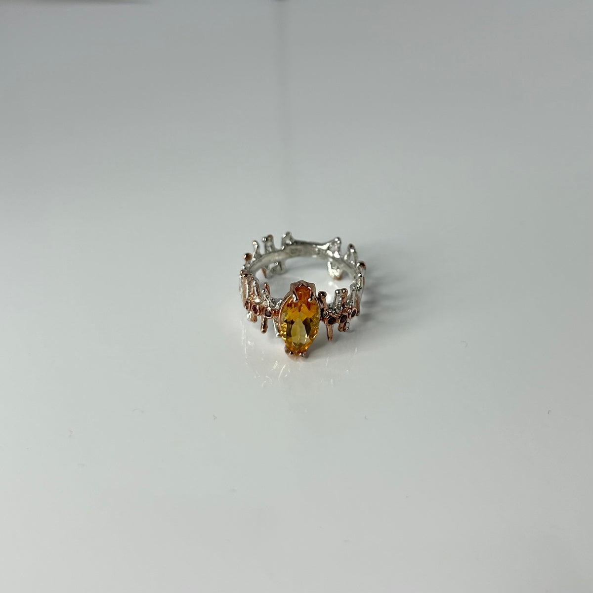 Silver ring with a yellow Citrine gemstone on a white background