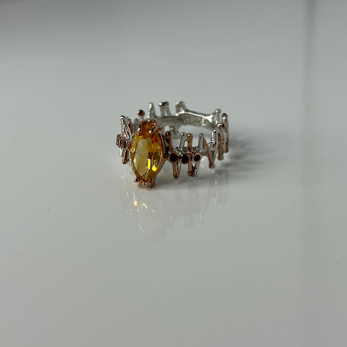 Silver ring with a yellow Citrine gemstone on a white background