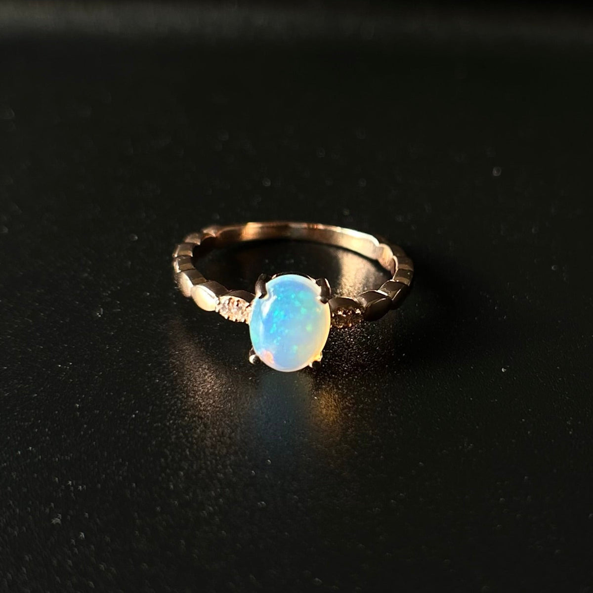 Silver ring with a blue opal stone on a black background