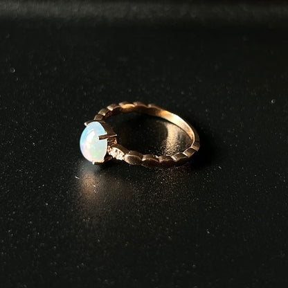 Silver ring with an opal stone on a black background