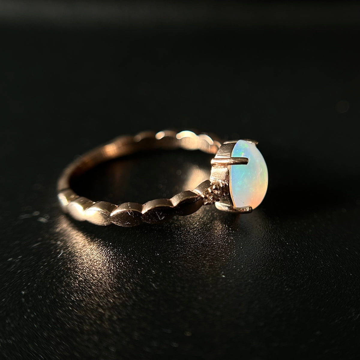 Silver ring with an opal stone on a black background