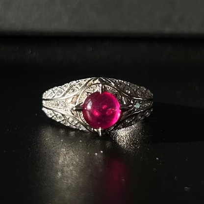 Silver ring with a red ruby on a black background
