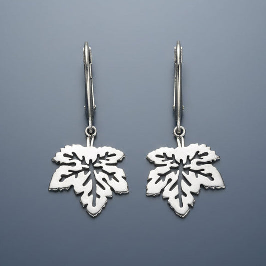 Silver leaf-shaped earrings on a gray background