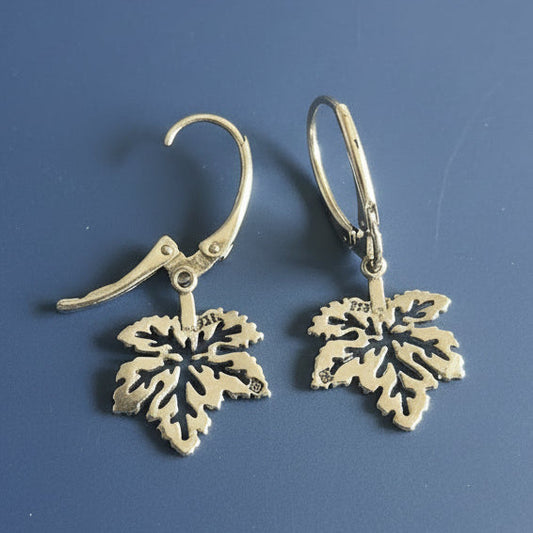 Silver leaf-shaped earrings on a blue background