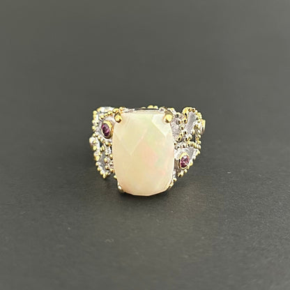 Ring with a large central opal and smaller stones on a dark background