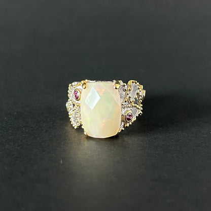 Silver ring with a large central opal and smaller stones on a black background