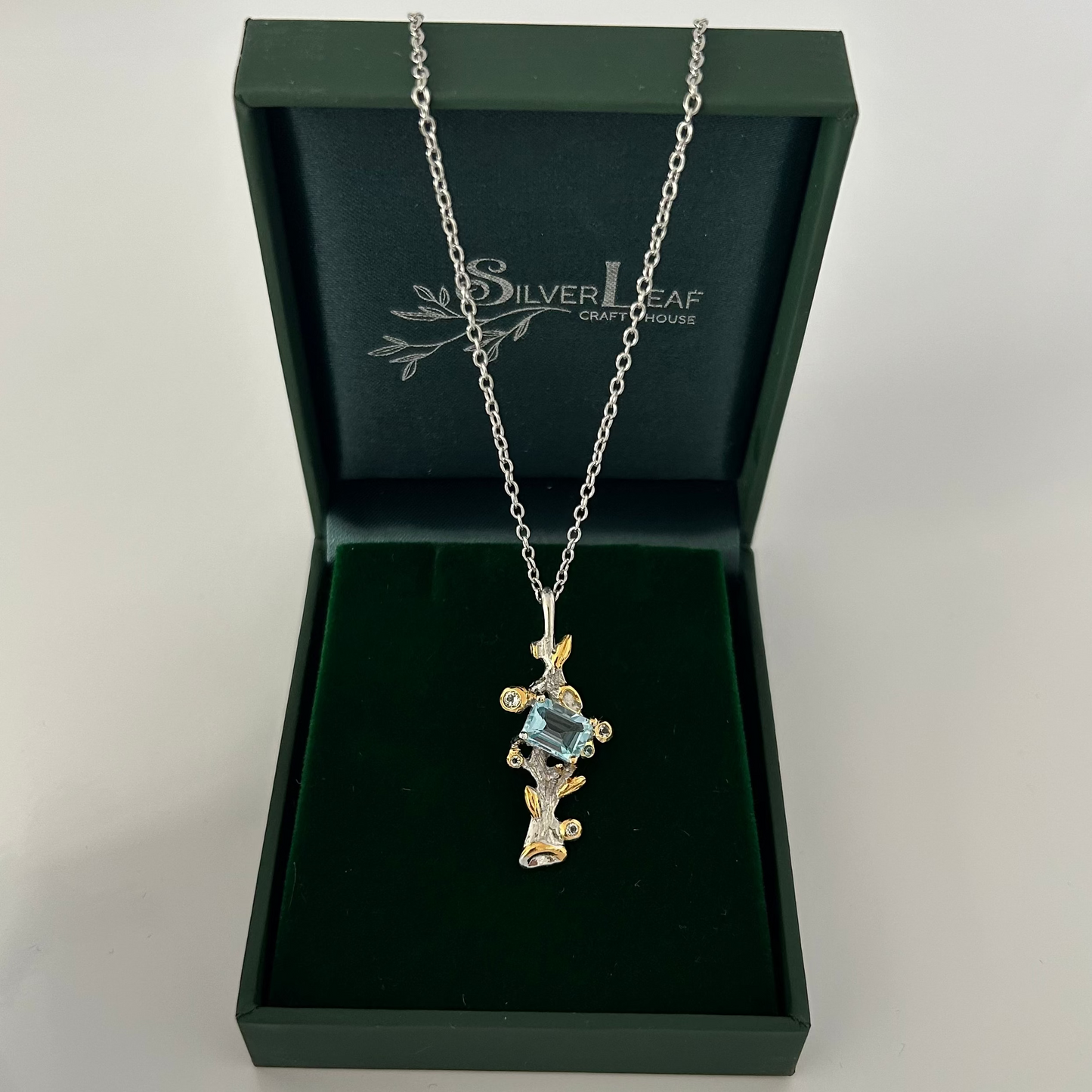 Silver necklace with pendant in a 'Silverleaf' box on a white background