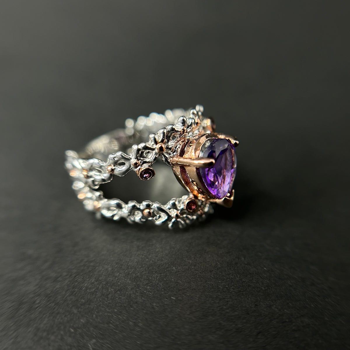 Silver ring with a purple amethyst gemstone on a black background