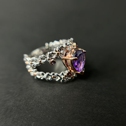 Silver ring with a purple amethyst gemstone on a black background
