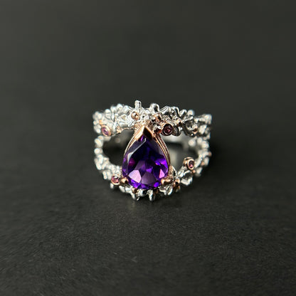 Silver ring with a purple amethyst gemstone on a black background