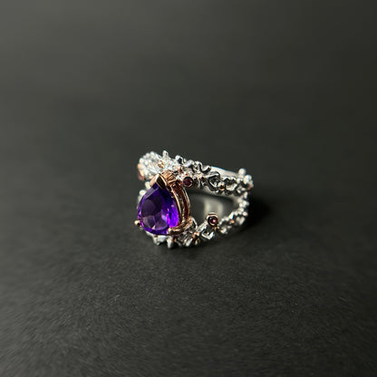 Silver ring with a purple amethyst gemstone on a black background