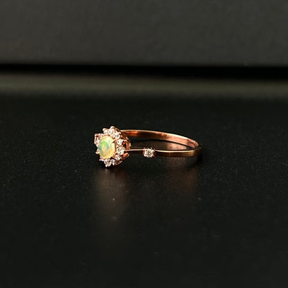 Silver ring with an opal stone on a black surface.