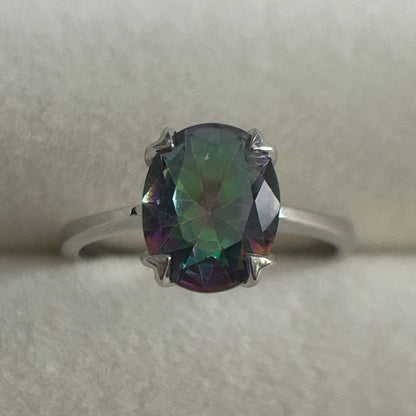 Ring with a mystic quartz gemstone on a light gray background