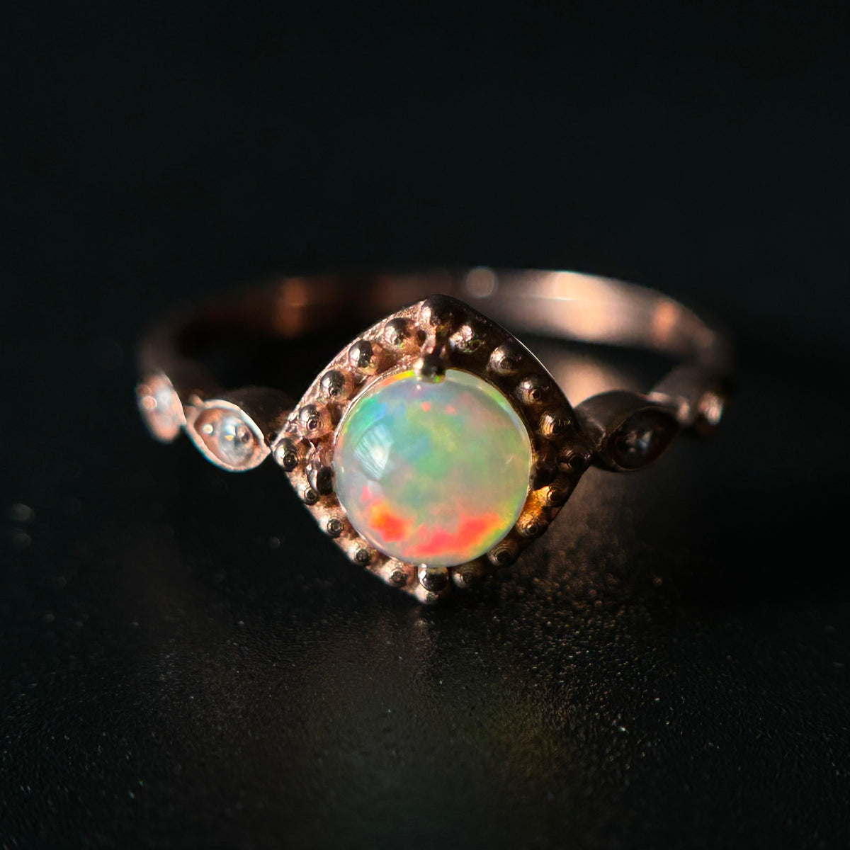 Opal ring with a black background