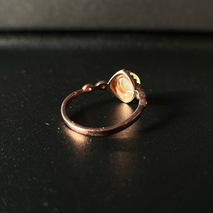 Silver ring with a central opal on a dark background