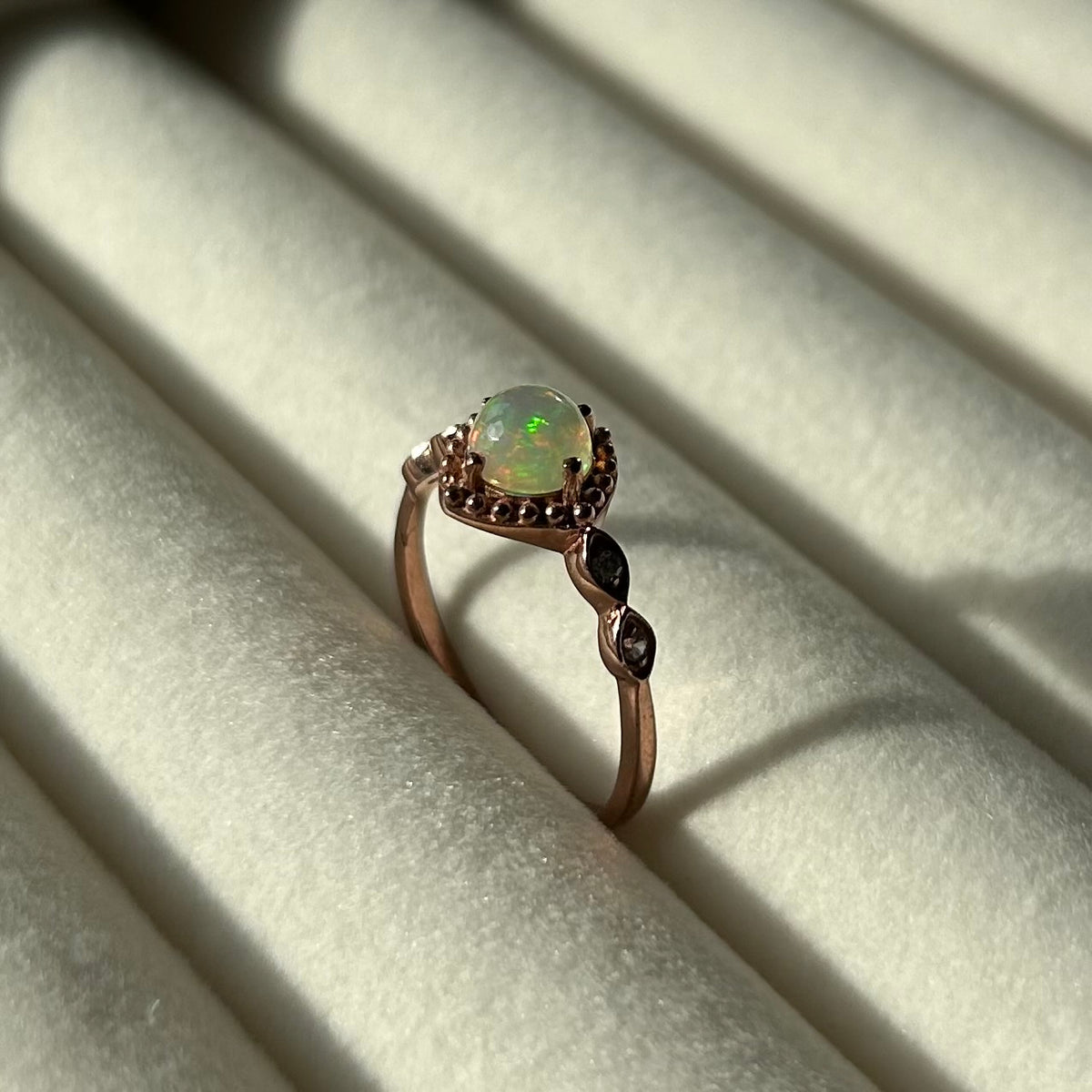 Silver ring with a central opal on a light background