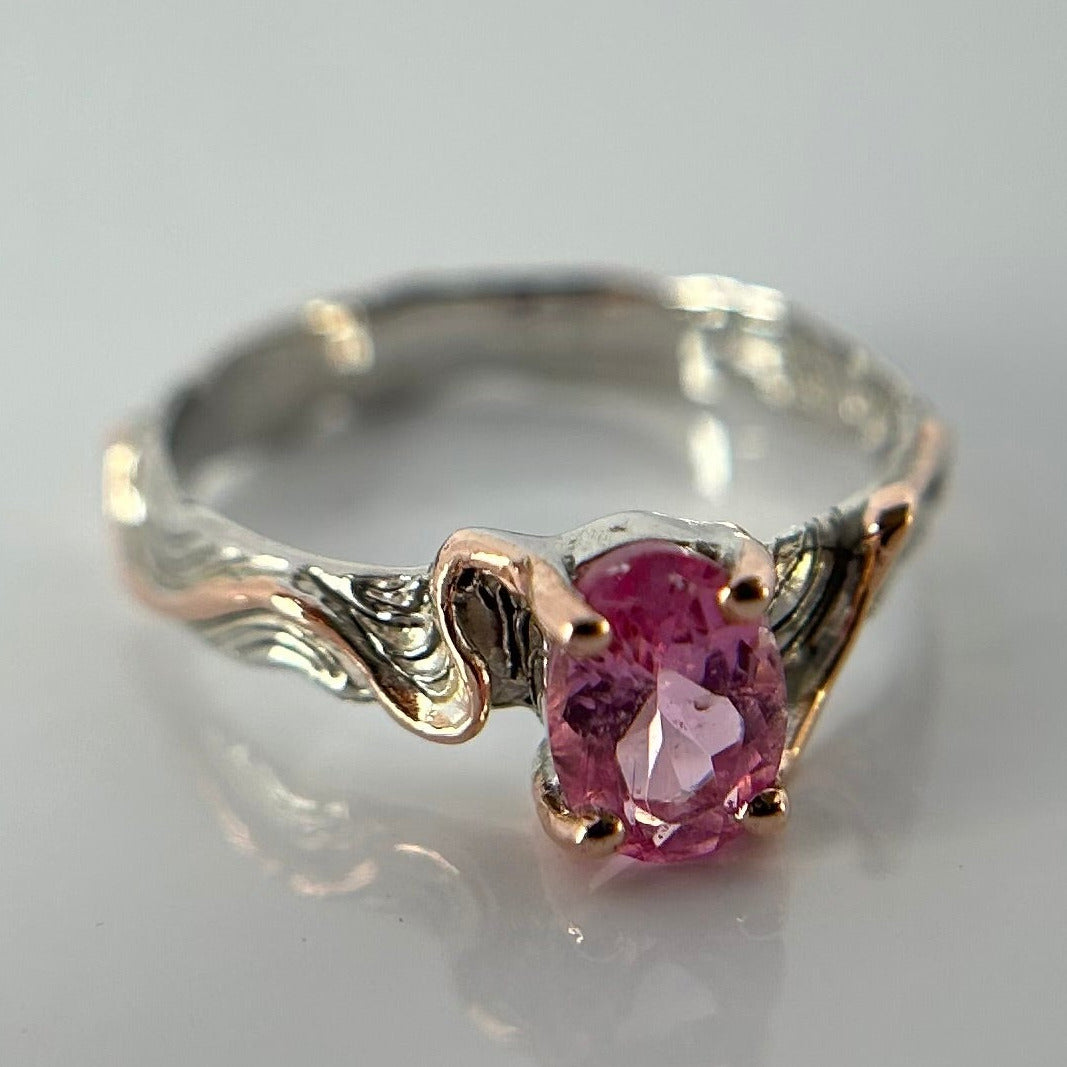 Silver ring with a pink tourmaline gemstone on a light gray background