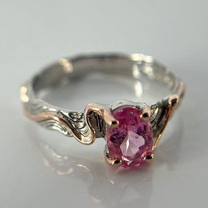 Silver ring with a pink tourmaline gemstone on a light gray background