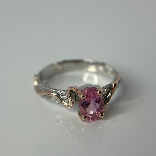 Silver ring with a pink gemstone on a gray background