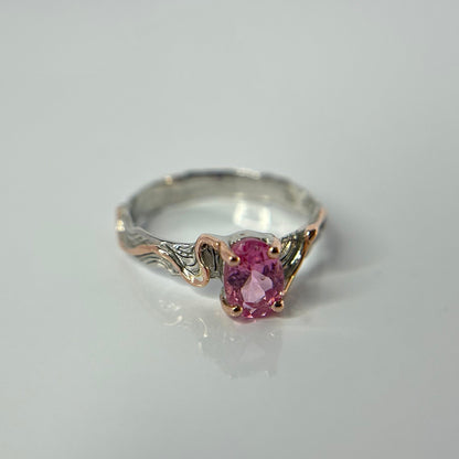 Silver ring with a pink tourmaline gemstone on a light gray background